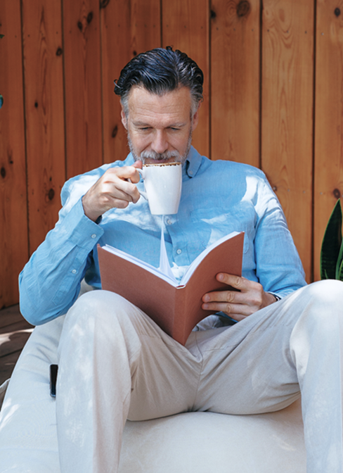 Bild-man-laser-bok-och-dricker-kaffe.png