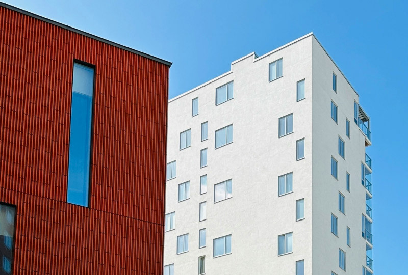 Rött och vitt bostadshus mot blå himmel..jpg